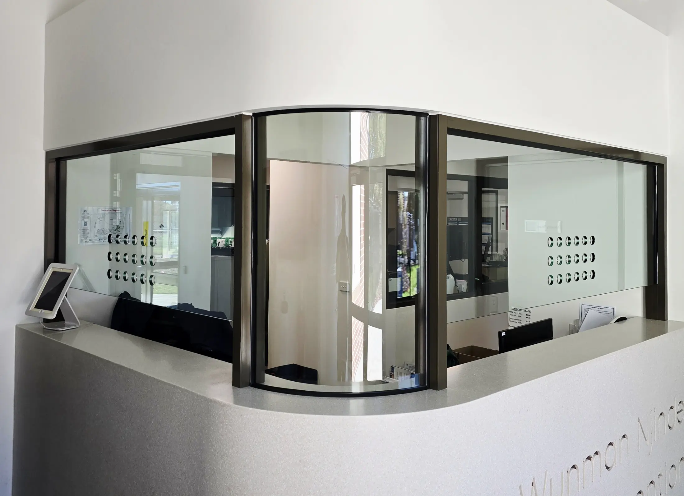 Curved aluminium framed glazing set into a commercial reception counter