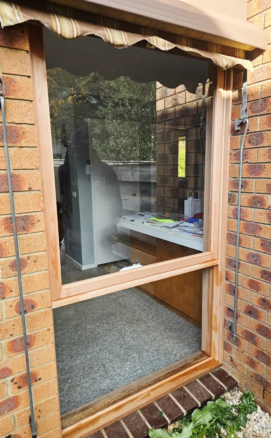 Timber framed window being reglazed in a brick house wall