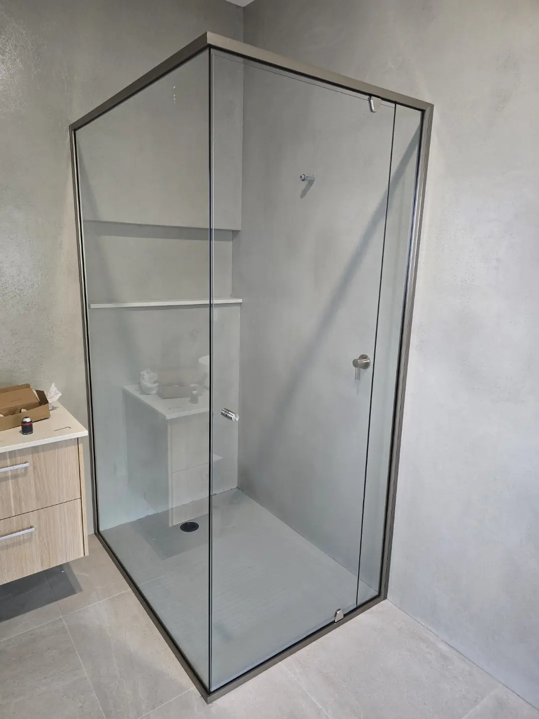 Semi frameless shower screen enclosure in a bathroom corner