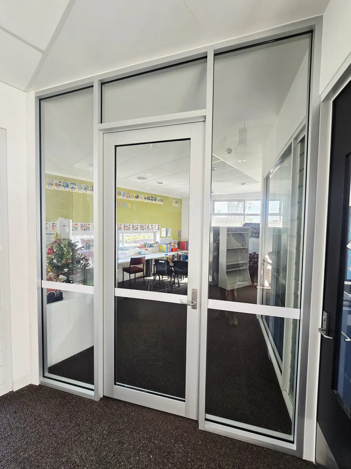 Aluminium framed glass entry doors and side panels installed in a commercial building